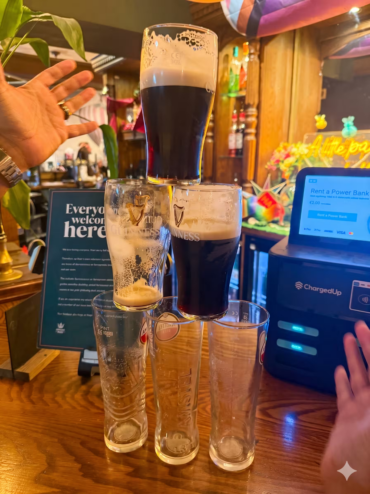 A tall stack of pint glasses on a bar counter for a team coordination game.