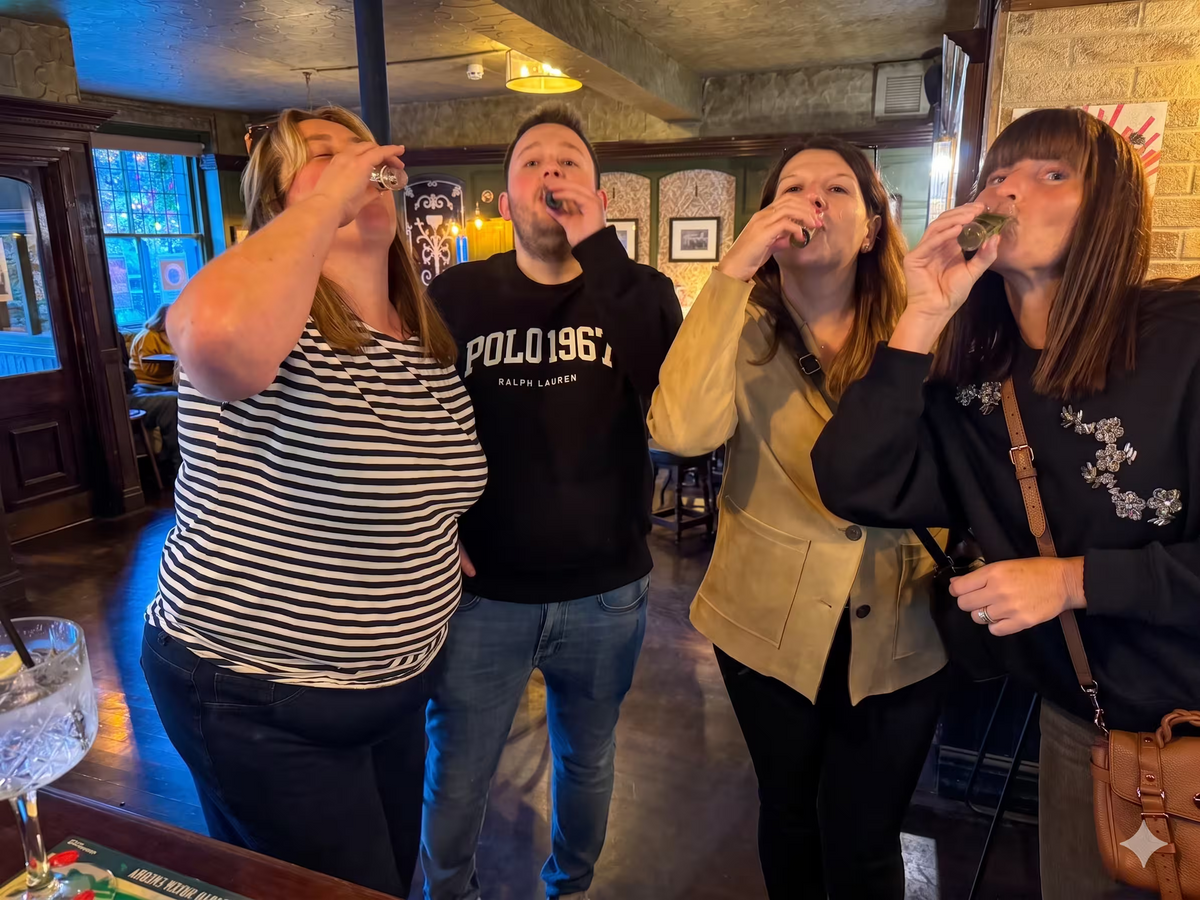 A small group of friends or colleagues enjoying drinks together at a bar during an event.