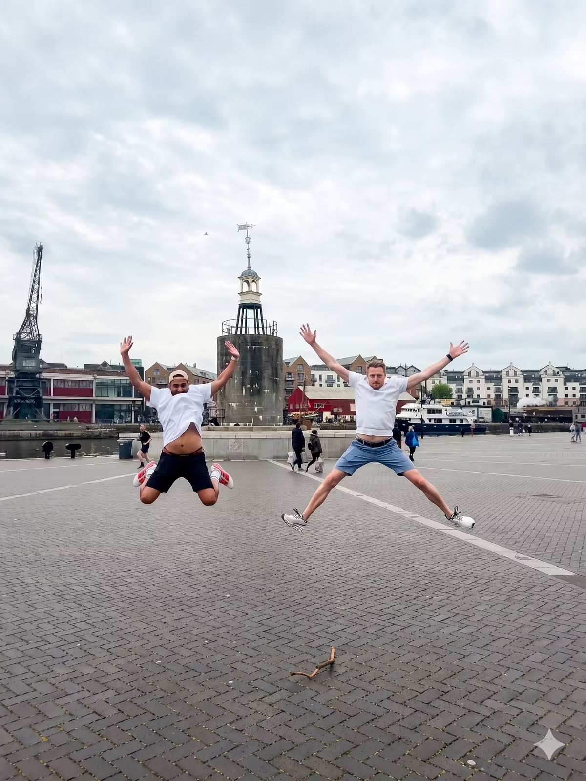 Two people jumping in the air in a city square for a high-energy team photo challenge.