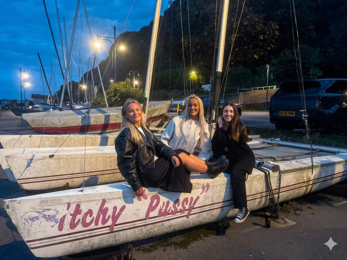 Three participants sitting on a dry-docked boat at a harbor during a scavenger hunt.