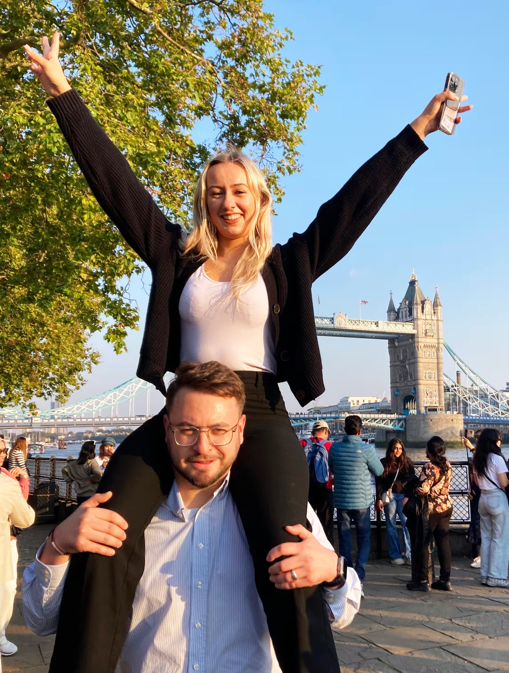Coworkers collaborating on a fun team-building task by posing with team members on each other's shoulders.